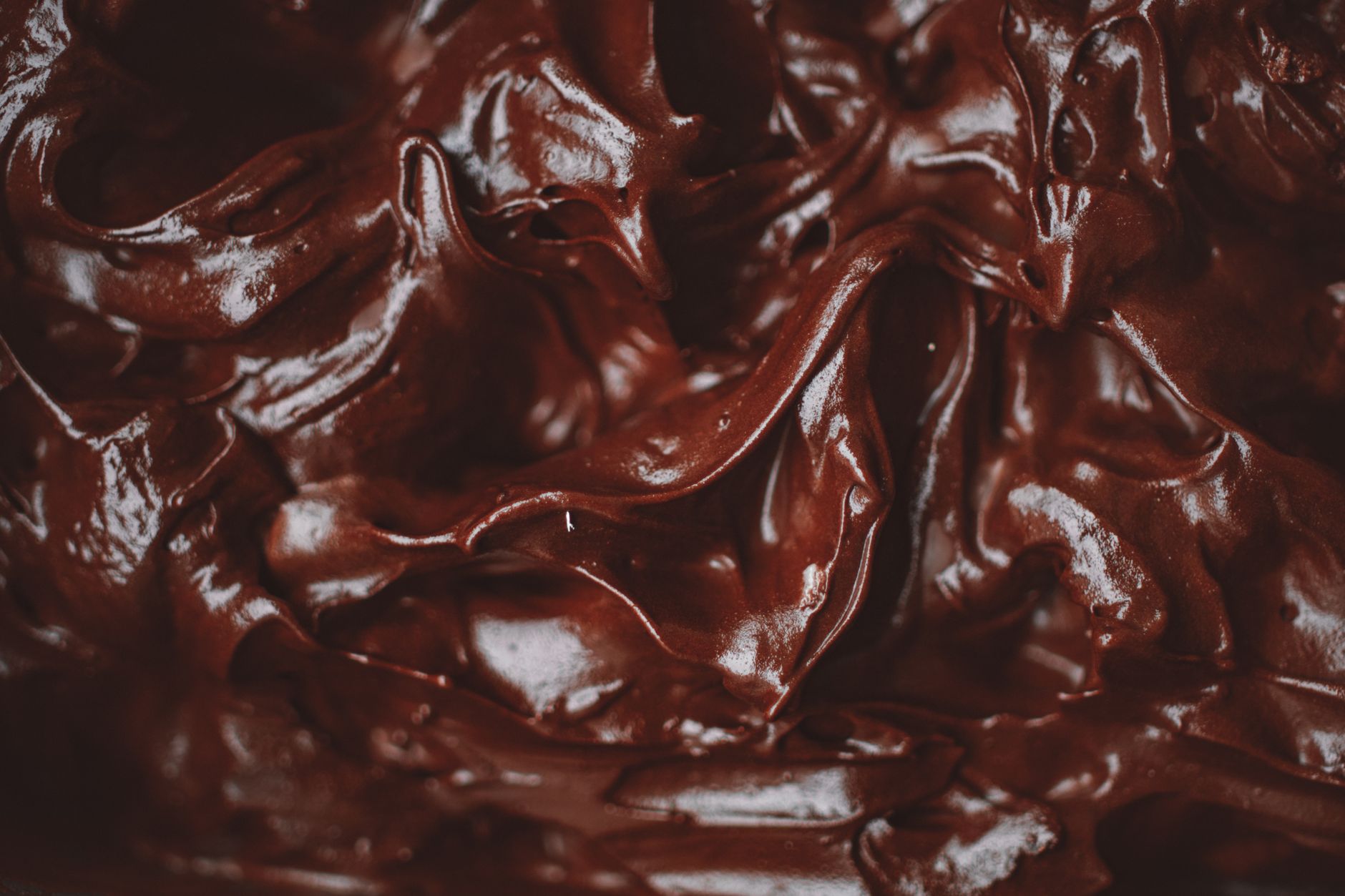 Close-up de um ganache de chocolate decadente e aveludado, mostrando sua textura rica.