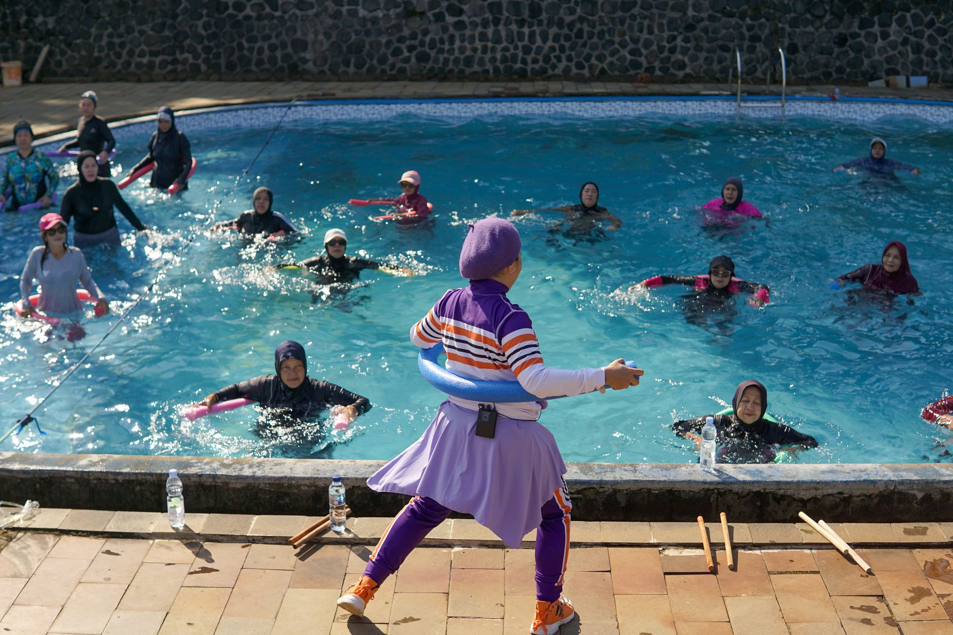 Mulheres participando de uma aula de hidroginástica ao sol em Java Ocidental, Indonésia.