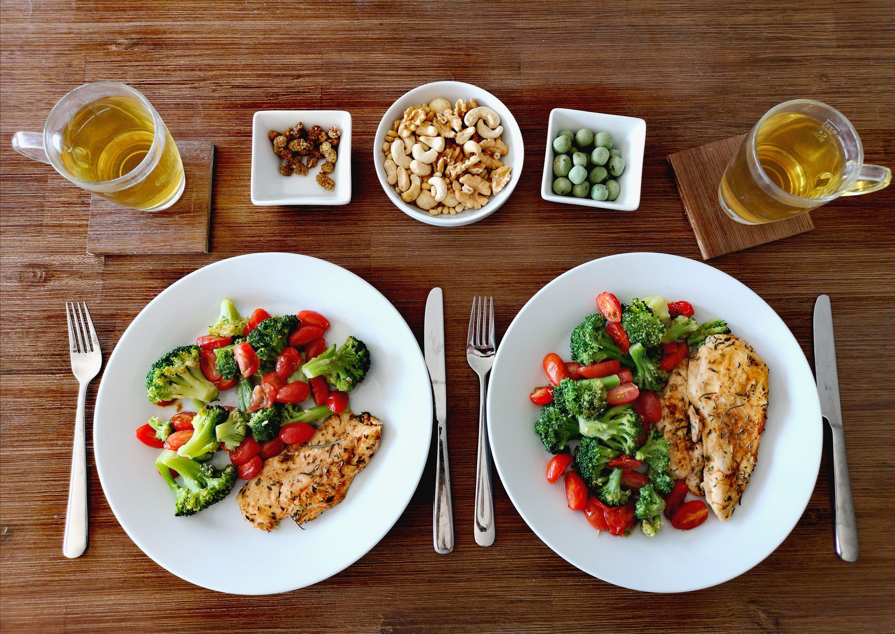 Um delicioso e saudável jantar de frango com vegetais frescos, nozes e chá em um ambiente aconchegante.