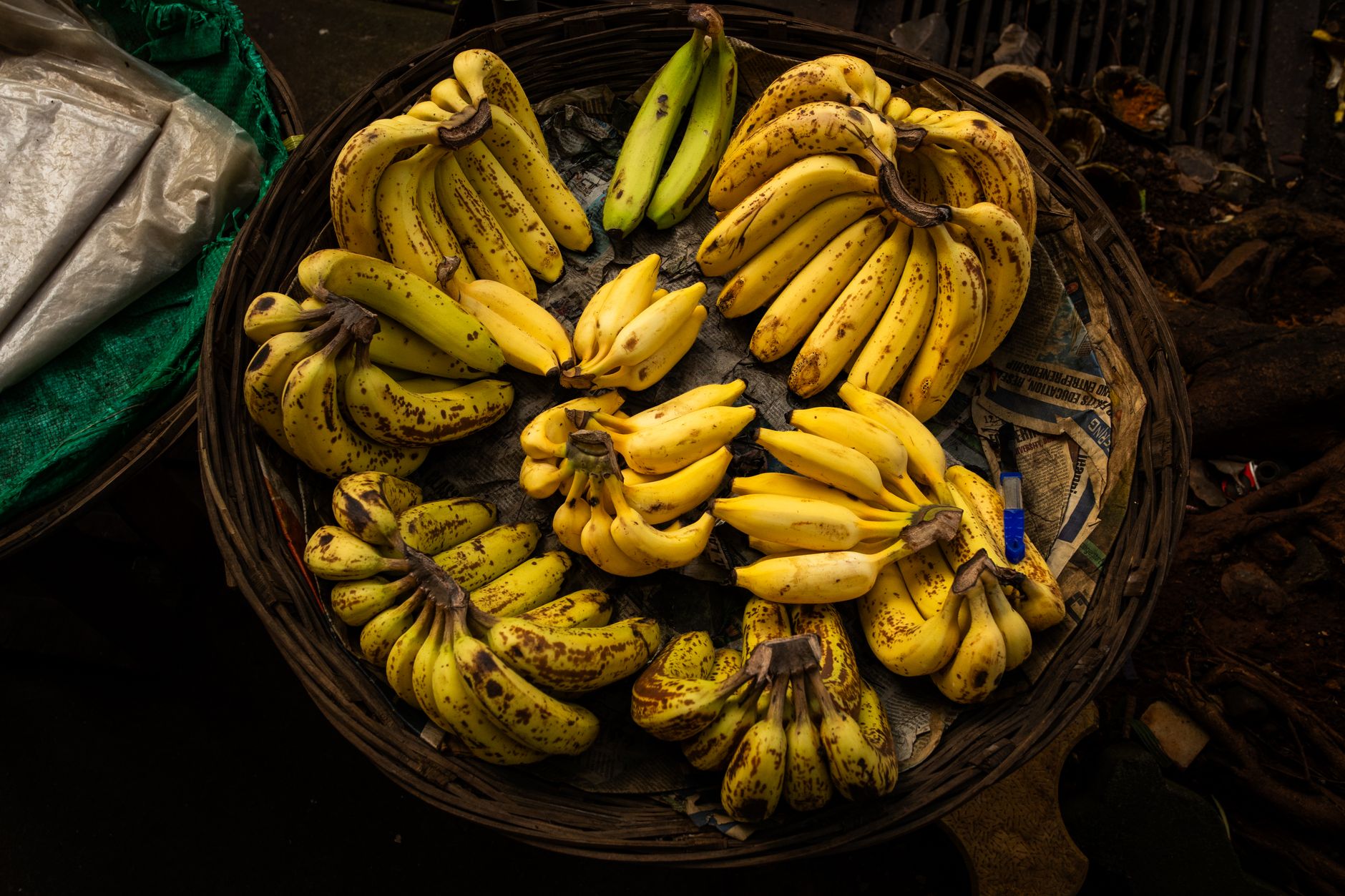 Vista aérea de bananas maduras em uma cesta de vime em um mercado de rua em Mumbai, Índia.