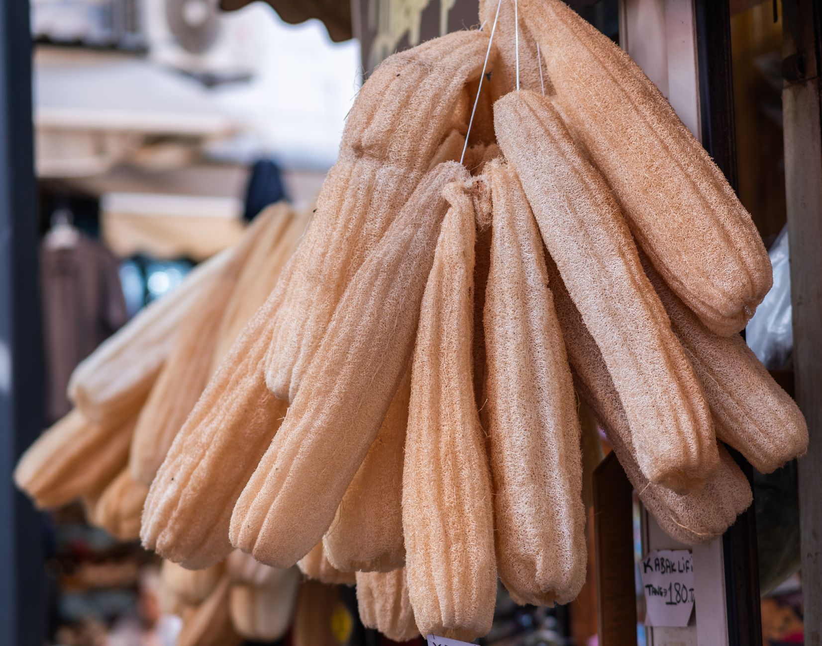 Esponjas de bucha penduradas em um mercado de Izmir, perfeitas para esfoliação natural e decoração de casa.