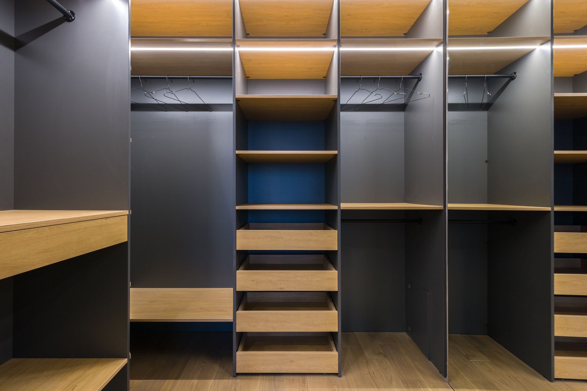 Amplo closet moderno com prateleiras de madeira e design elegante, ideal para organização.