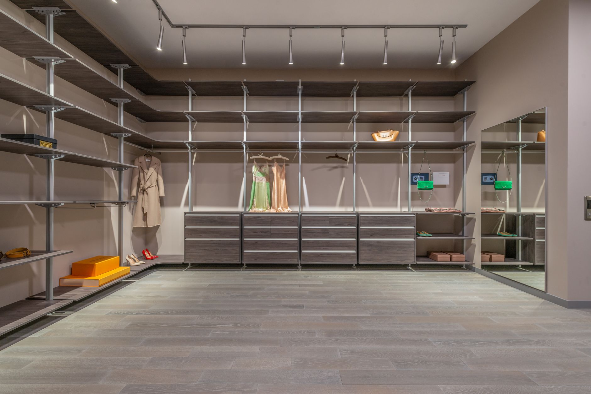 Amplo closet walk-in moderno com armários elegantes e exibição de roupas de designer.